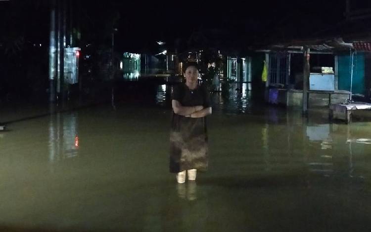 Potret Anggota DPRD Gunung Mas Sahriah saat berada di genangan banjir. (FOTO: IST)