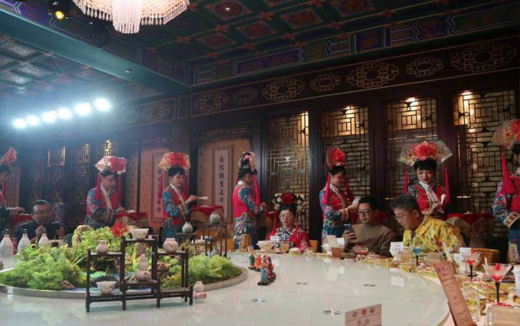 Pelayan yang memakai kostum Dinasti Qing menghidangkan makanan di Restoran Yuxiandu, yang disebut sebagai "museum kuliner Kekaisaran Beijing", di Kota Beijing, China, Jumat (29/11/2024). (ANTARA/Desca Lidya Natalia)