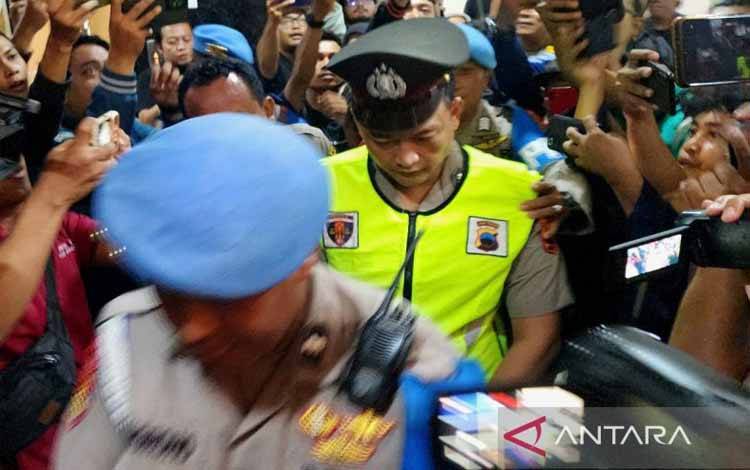 Anggota Polrestabes Semarang Aipda R, terduga pelaku penembakan siswa SMKN 4 Kota Semarang, GRO, saat memasuki ruang sidang Bidang Propam Polda Jawa Tengah di Semarang, Senin (9/12/2024). (ANTARA/I.C. Senjaya)