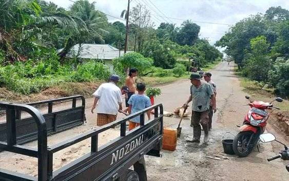 Babinsa dan Warga Desa Sumur Gotong Royong Cor Jalan Nasional yang Rusak