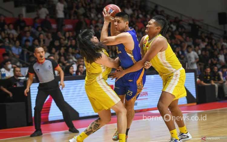 Pebasket Satria Muda Pertamina Jakarta Avan Seputra (tengah) mendapatkan pengawalan ketat dari pebasket Ksatria Bengawan Solo Bryan Adha Elang Praditya (kanan) dan Esha Lapian (kiri) dalam laga penyisihan Grup A IBL All Indonesian Piala Menpora di Hall Basket Senayan, Gelora Bung Karno, Jakarta, Minggu (22/9/2024). ANTARA FOTO/Hafidz Mubarak A/app/Spt