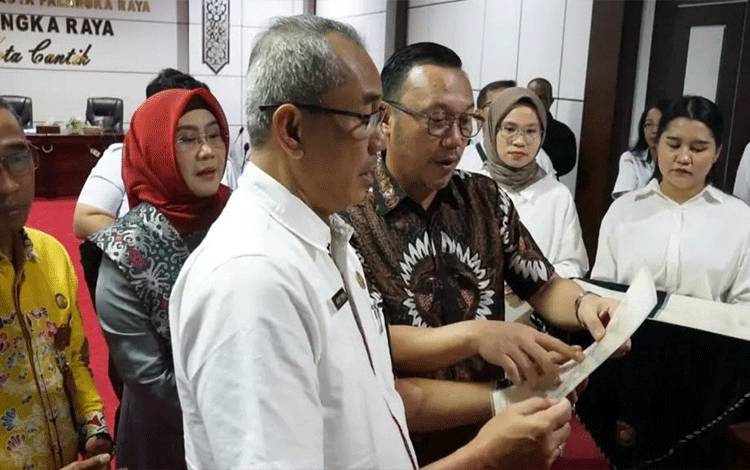 Pj Sekda Palangka Raya, Arbert Tombak saat penyerahan sertifikat HAT. (FOTO: HUMAS)?