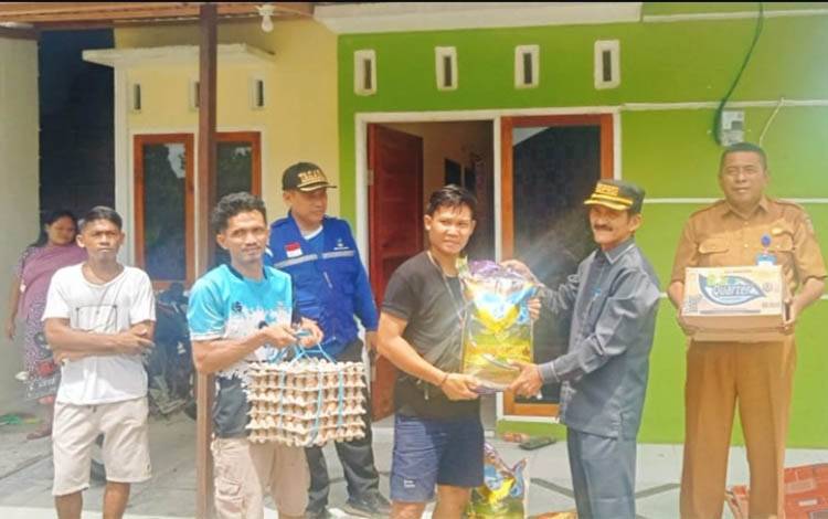 Ketua DPRD Kobar Mulyadin saat menyerahkan paket sembako pada warga terdampak musibah angin kencang.