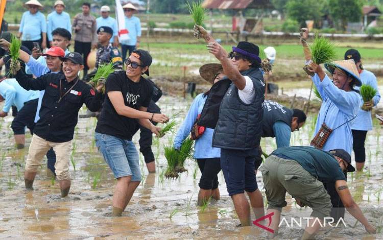 Tampak para personel grup band Slank, Ridho dan Kaka saat menanam padi bersama Pj Gubernur Kaltim Akmal Malik di lahan bekas Tambang PT BBE, Loa Duri Ulu, Kabupaten Kutai Kartanegara, Kamis (9/1/2025). (ANTARA Foto/ M Risyal Hidayat)