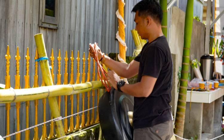 Pemangku Agama Hindu Kaharingan mengikat alat musik garantung pada bambu saat persiapan ritual Pakanan Sahur dan Mapas Lewu Pahandut di Balai Basarah Tuyang Hasuling Riwut Kota Palangka Raya. (FOTO: HUMAS)
