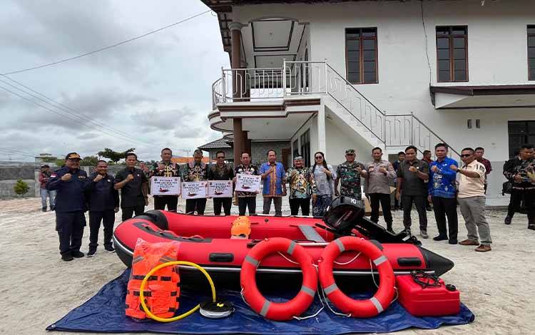 Asisten III Setda Kapuas, Ahmad M Saribi saat menyerahkan bantuan berupa 1 paket perahu karet beserta perlengkapannya untuk sejumlah kecamatan yang terdampak banjir. (FOTO: IST)