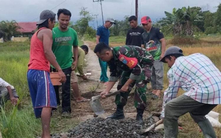 Babinsa 1011-02 Kapuas Hilir Sertu Joko Purnomo bersama warga gotong royong. (FOTO: IST)