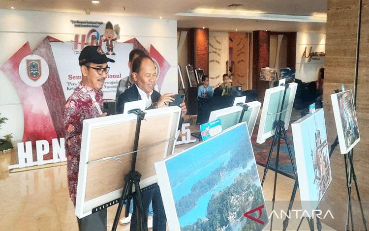 Peserta HPN saat melihat foto-foto yang dipamerkan di rangkaian Hari Pers Nasional (HPN) 2025 di Banjarmasin. (ANTARA/Firman)