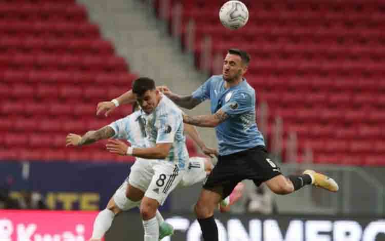 Pemain Uruguay Luis Suarez berebut bola dengan pemain Argentina Marcos Acuna pada pertandingan Copa America 2021 Grup A di Estadio Mane Garrincha, Brasilia, Brazil, sabtu (19/6/2021). Argentina unggul tipis 1-0 melalui gol Guido Rodriguez. ANTARA FOTO/REUTERS/Henry Romero/pras.