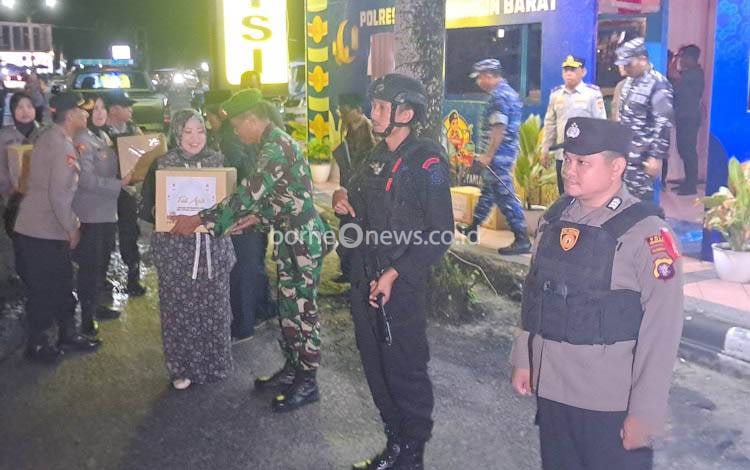 Bupati Kobar Nurhidayah saat menyerahkan bingkisan pada personel pengamanan yang bertugas di Pos Bundaran Pancasila, Minggu, 30 Maret 2025.