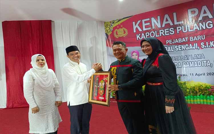 AKBP Mada Ramadita beserta Istri menerima cendra mata dari Bupati Pulang Pisau Ahmad Rifa'i beserta Istri, Jumat 11 April 2025 malam. (FOTO : RETHA)