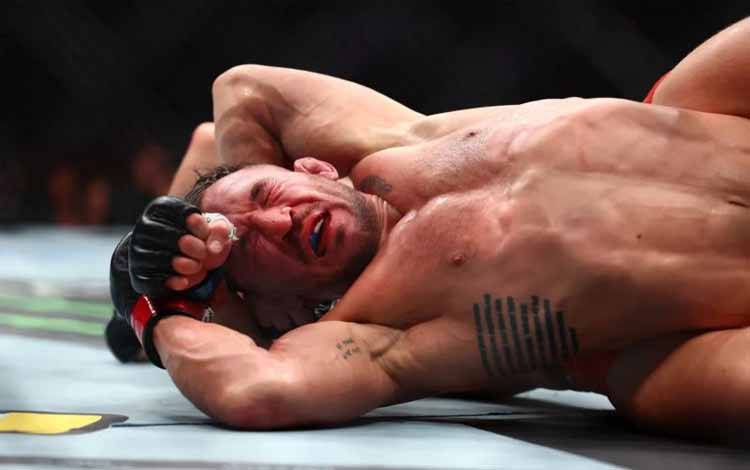 Petarung UFC Michael Chandler mendapat serangan dari lawannya Paddy Pimblett dalam pertarungan mereka pada ajang UFC 314 di Miami, Amerika Serikat, Sabtu (12/4/2025). (Laman MMA Fighting/Megan Briggs/Getty Images)