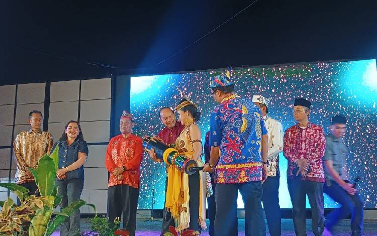 Asisten I Setda Gumas Lurand saat menabuh ketambung tanda dibukanya pagelaran seni budaya Gunung Mas Menari 2025, Selasa, 29 April 2025 malam. (FOTO: RISKA YULYANA)