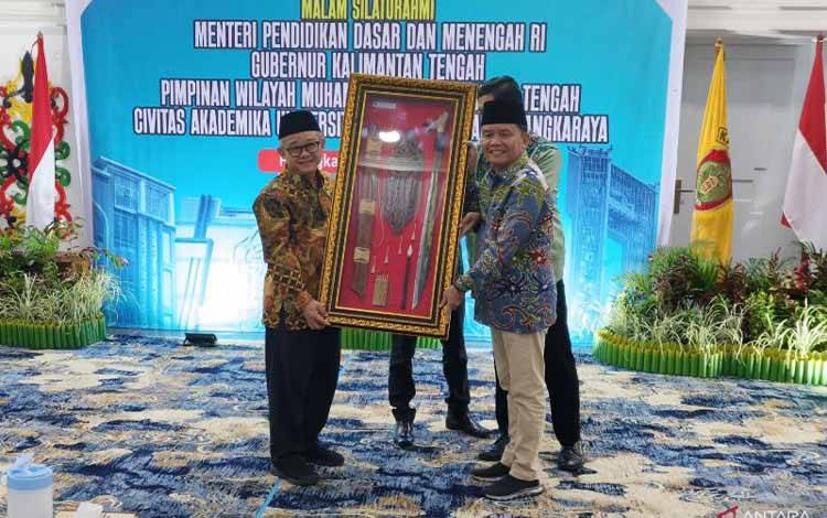 Menteri Pendidikan Dasar dan Menengah (Mendikdasmen) Abdul Mu'ti menerima cenderamata dari Gubernur Kalimantan Tengah Agustiar Sabran di Palangka Raya, Jumat (9/5/2025) malam. ANTARA/Muhammad Arif Hidayat