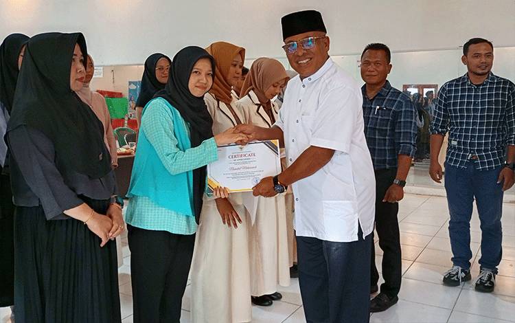 Wakil Bupati Kobar Suyanto berikan penghargaan apresiasi kepada puluhan relawan Kelas Berbagi Pondok Baca Kelurahan Sidorejo, Kecamatan Arut Selatan, Sabtu, 24 Mei 2025. (FOTO: NURITA)