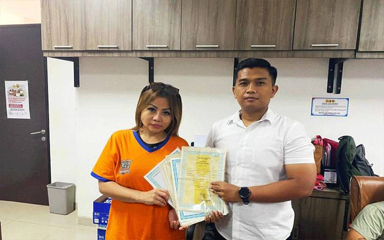 Tersangka kasus penggelapan sekaligus pemilik UD Sentoso Seal Jan Hwa Diana mengembalikan ijazah milik mantan karyawannya yang sempat ditahan kepada penyidik. ANTARA/HO-Polda Jatim