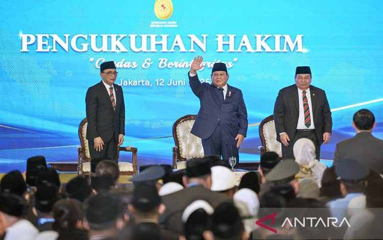 Presiden Prabowo Subianto (tengah) didampingi Ketua Mahkamah Agung (MA) Sunarto (kiri) dan Wakil Ketua Mahkamah Agung bidang non Yudisial Suharto (kanan) melambaikan tangan kepada para hakim baru usai upacara pengukuhan di Gedung MA, Jakarta, Kamis (12/6/2025). ANTARA FOTO/Aditya Pradana Putra/bar/aa.