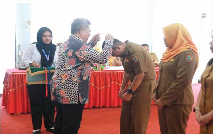 Penyematan tanda peserta oleh Kepala Pusat Pengembangan Aparatur Komdigi RI Noor Iza. (FOTO:ASEF)