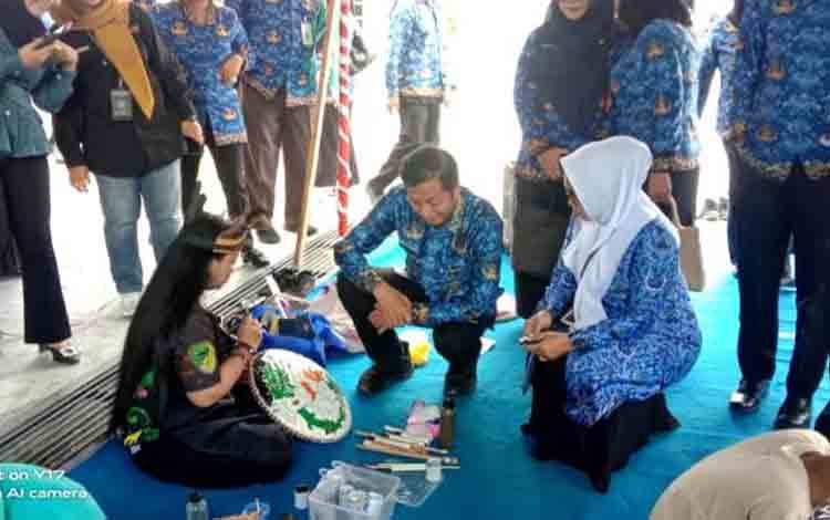 Sekda Barito Utara, Drs Muhlis didampingi Kepala Dinas Budparpora Barito Utara, Hj Annisa Cahyawati melihat langsung para peserta lomba lukis ornamen, di halaman Dinas Budparpora setempat. (Foto: Dhani)