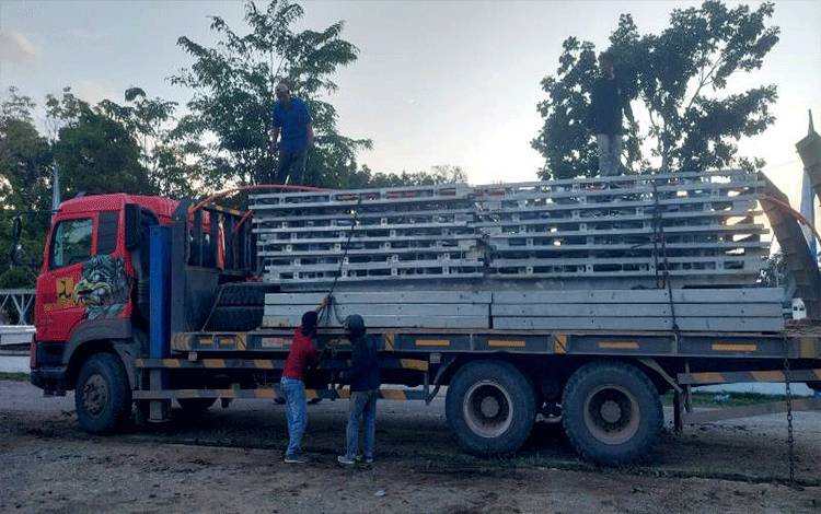Proses pengangkutan material jembatan ke atas dua unit truk trailer, yang diberangkatkan menuju lokasi pembangunan jembatan Desa Tawan Jaya. (foto: Dhani)