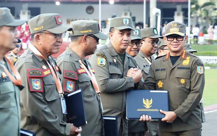 Wamendagri Bima Arya Sugiarto saat menyerahkan sertifikat kepada Bupati Lamandau Rizky Aditya Putra di akhir kegiatan retret. FOTO : PPOST/FAHRUDDIN FITRIYA
