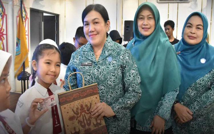 Pj Ketua Dharma Wanita Persatuan (DWP) Kabupaten Kapuas, Sylvia Veronita Usis I. Sangkai, secara simbolis menyerahkan Kartu Identitas Anak (KIA) dalam acara yang diadakan serentak se-Kalimantan Tengah di Ruang Rapat Rujab Bupati Kapuas, Rabu, 16 Juli 2025 (IST)