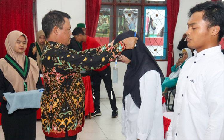 Bupati Seruyan Ahmad Selanorwanda mengalungkan tanda peserta kegiatan Latihan Kader 1 (LK I) HMI Komisariat Lafran Pane Seruyan (Foto : Ist)