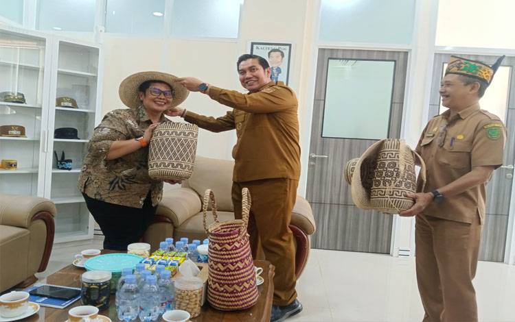 Tim Balai Pelestarian kebudayaan wilayah XIII provinsi Kalteng - Kalsel, Riris Purbasari, saat menerima cendramata berupa tas dan topi rotan usai audensi, Selasa 22 Juli 2025. (FOTO : RETHA)