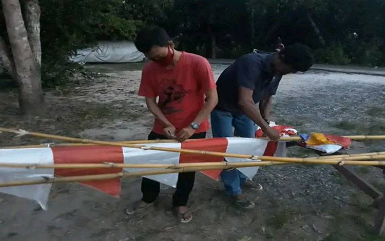 Warga Jalan Pemuda, Kuala Kapuas ketika bergotong royong melakukan pemasangan umbul-umbul di lingkungannya, Minggu, 3 Agustus 2025. (SABRI)