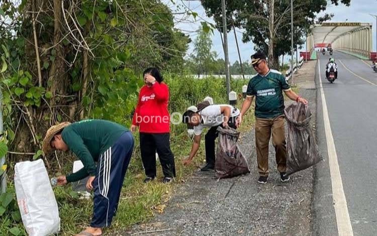 Camat Kapuas Hilir, Nazmiannoor bersama warga Kapuas Hilir terjun langsung memungut sampah di sekitar kawasan Jembatan Pulau Petak, Kapuas Hilir, Kamis, 14 Agustus 2025. (IST)