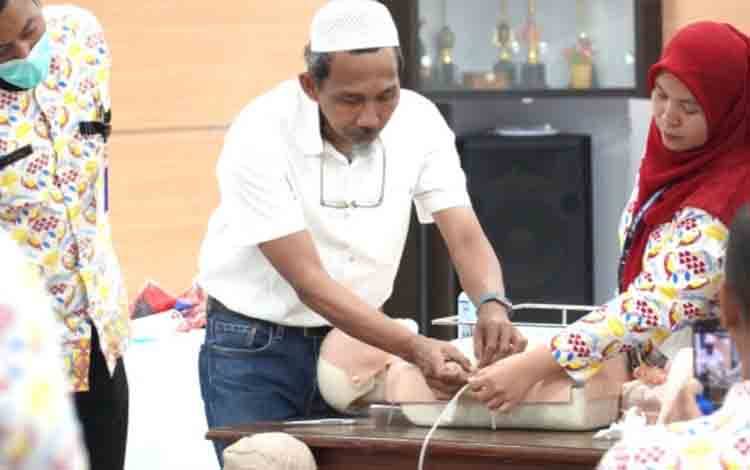 dr. Asep Agus Supriatna, Sp.B, saat memberikan materi praktik langsung terkait prosedur medis kateter urine dan perawatan WSD.