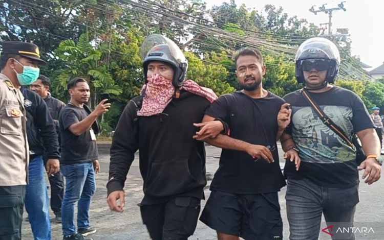 Anggota Kepolisian Daerah Bali menangkap seorang demonstran saat aksi di depan Mapolda Bali Denpasar, Sabtu (30/8/2025). ANTARA/Rolandus Nampu.