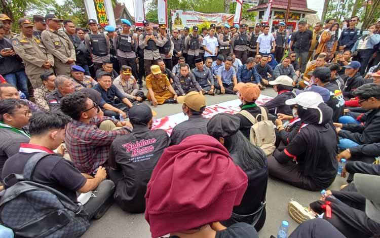 Anggota DPRD Kotawaringin Timur, Kapolres Kotim, dan Pj Sekda Kotim duduk di Jalan Jenderal Sudirman bersama para demonstran, Senin, 1 September 2025. (FOTO: DEWIP)
