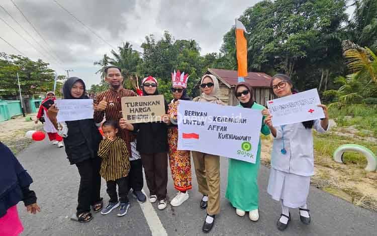 Kades Sebuai Tohari bersama pemuda desa swa foto bersama sembari menunjukkan tulisan tuntutan kepada pemerintah.
