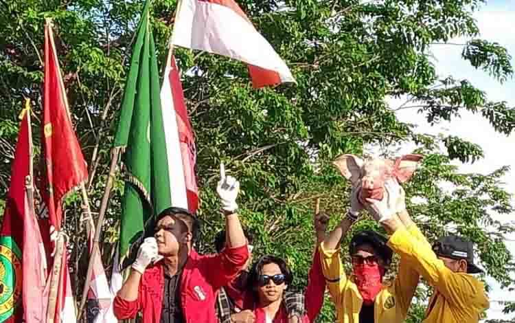Demonstran dari Massa Aliansi Gerakan September Hitam mengangkat kepala babi saat melakukan aksi unjuk rasa di depan Kantor DPRD Kalteng, Senin, 1 September 2025. (Foto : IST)