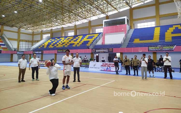 Bupati Kobar Hj.Nurhidayah melakukan lemparan bola basket sebagai tanda dimulainya Kompetisi Basket Ball Bupati Cup 2025.