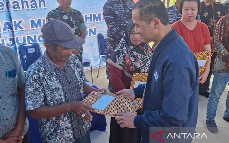 Menteri Transmigrasi Muhammad Iftitah Sulaiman Suryanagara menyerahkan sertifikat hak milik kepada warga Rempang yang mengikuti program transmigrasi ke Tanjung Banon, Provinsi Kepulauan Riau pada Kamis (25/9/2025). (ANTARA/Aji Cakti)