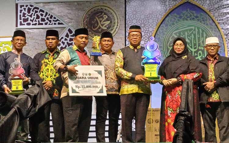 Camat Mentawa Baru Ketapang Irpansyah menerima piala juara umum MTQ dari Wakil Bupati Kotawaringin Timur Irawati, Rabu, 1 Oktober 2025. (FOTO: DEWIP)