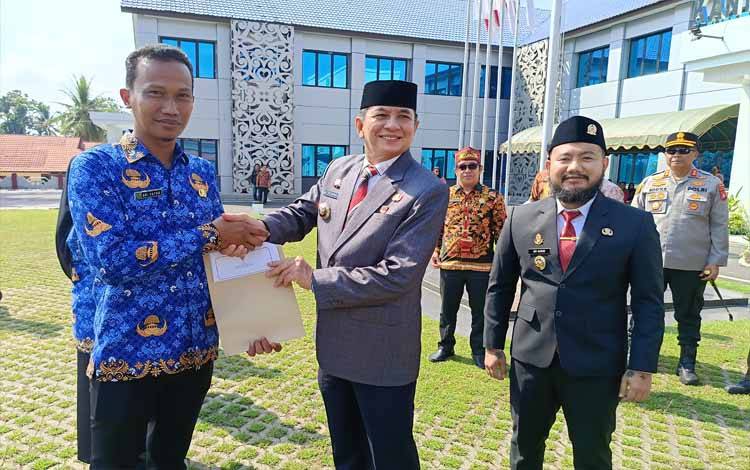 Bupati Barito Timur M Yamin, didampingi Wakil Bupati Adi Mula Nakalelu dan unsur Forkopimda, menyerahkan secara simbolis surat keputusan pengangkatan 446 PPPK, Jumat, 3 Oktober 2025. (FOTO: AGUSTINUS BOLE MALO)