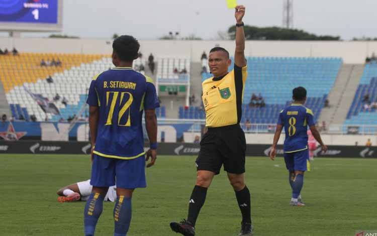 Wasit Steven Yubel Poli (kanan) memberi hukuman kartu kuning pada pesepak bola Arema FC Bayu Setiawan (kiri) usai melakukan pelanggaran kepada pesepak bola Borneo FC dalam pertandingan BRI Super League 2025 di Stadion Kanjuruhan, Malang, Jawa Timur, Minggu (26/10/2025). Borneo FC menang atas Arema FC dengan skor akhir 3-1. ANTARA FOTO/ARI BOWO SUCIPTO