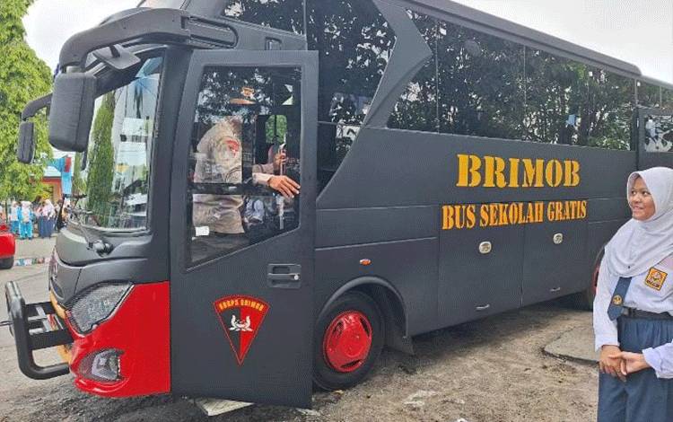 Seorang anggota Brimob Polda Kalteng saat menyapa siswa yang hendak naik bus gratis, Selasa, 28 Oktober 2025. (FOTO: MARINI)
