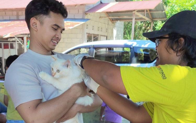 Vaksinator memberikan vaksin rabies kepada warga Panarung pada Sabtu, 1 November 2025. (FOTO: TESTI PRISCILLA)
