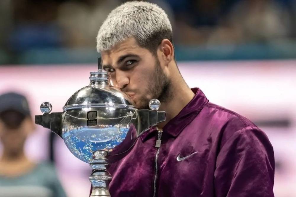 Petenis Spanyol Carlos Alcaraz mencium trofi usai mengalahkan petenis Amerika Serikat Taylor Fritz untuk memenangi Japan Open di Tokyo, Selasa (30/9/2025). ATP