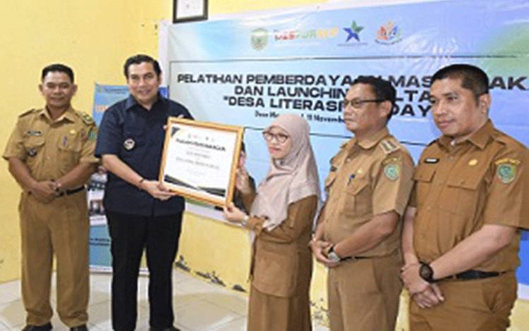 Kadis Dispursipda Pulpis drg Sopiyah menyerahkan piagam penghargaan atas launching program desa Literasi di desa Mentaren I, Selasa, 11 November 2025. (FOTO: RETHA)