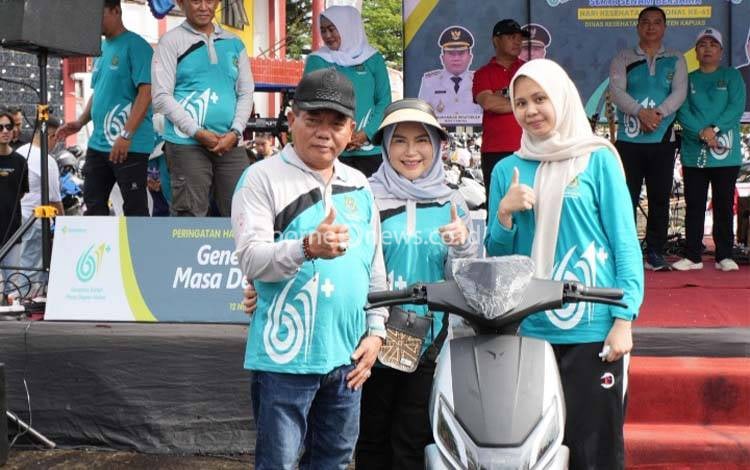 Bupati Kapuas, M. Wiyatno saat penyerahan doorprize dalam peringatan HKN ke- 61 di kawasan Stadion Panunjung Tarung, Kuala Kapuas, Minggu, 16 November 2025. (FOTO: Diskominfo Kps)