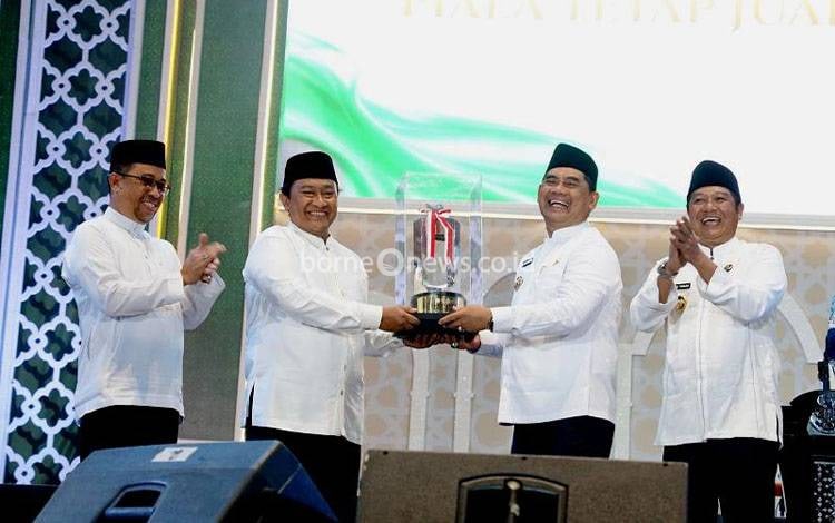 Wakil Gubernur Kalteng H Edy Pratowo menyerahkan piala juara umum MTQH ke XXXIII tingkat Provinsi Kalteng kepada kafilah Kabupaten Barito Utara yang diterima Bupati Barito Utara, H Shalahuddin didampingi Wakil Bupati Felix Sonadie Y Tingan pada malam penutupan, di Arena Tiara Batara, Jumat malam, 21 November 2025.(Diskominfosandi)