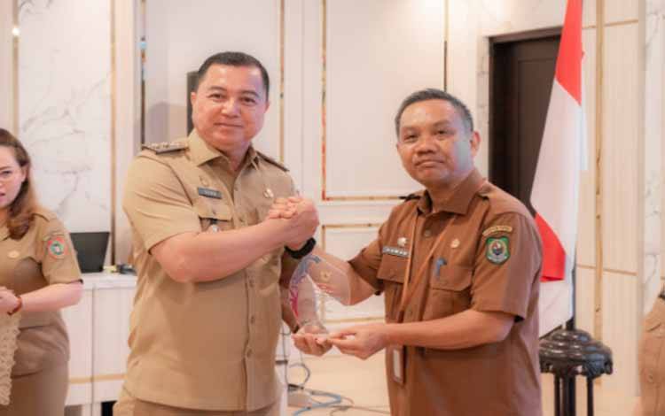 Penyerahan penghargaan kepada Kabupaten Kapuas dengan predikat sangat baik di pengawasan eksternal Kabupaten Kota Se- Provinsi Kalimantan Tengah pada Rapat Koordinasi Kearsipan Provinsi Kalimantan Tengah yang digelar di Aula Rumah Jabatan Bupati Kapuas, Selasa, 2 Desember 2025. (FOTO: Diskominfo Kps)