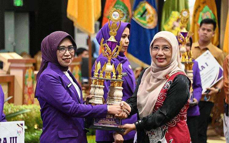 Penyerahan piala saat rangkaian Rakerda Tim Pembina Posyandu se-Kalimantan Tengah. (FOTO:BIRO ADPIM SETDA KALTENG)