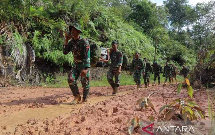 Personel TNI AD berjalan sambil menggotong genset dari Desa Parsingkaman melalui Aek Raisan dan Aek Mompang menuju Kelurahan Nauli, Sumatera Utara, Sabtu (6/12/2025) (ANTARA/HO-Humas TNI)