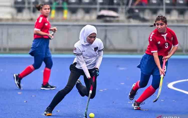 Foto arsip - Pemain hoki putri Indonesia Ayu (tengah) berusaha melewati adangan pemain Uzbekistan Khakimova (kanan) pada babak penyisihan Piala Asia Hoki atau AHF Cup 2025 di Lapangan Hoki Gelora Bung Karno, Senayan, Jakarta, Selasa (22/4/2025). Tim hoki putri Indonesia imbang melawan Uzbekistan dengan skor 1-1. ANTARA FOTO/Rivan Awal Lingga/nz